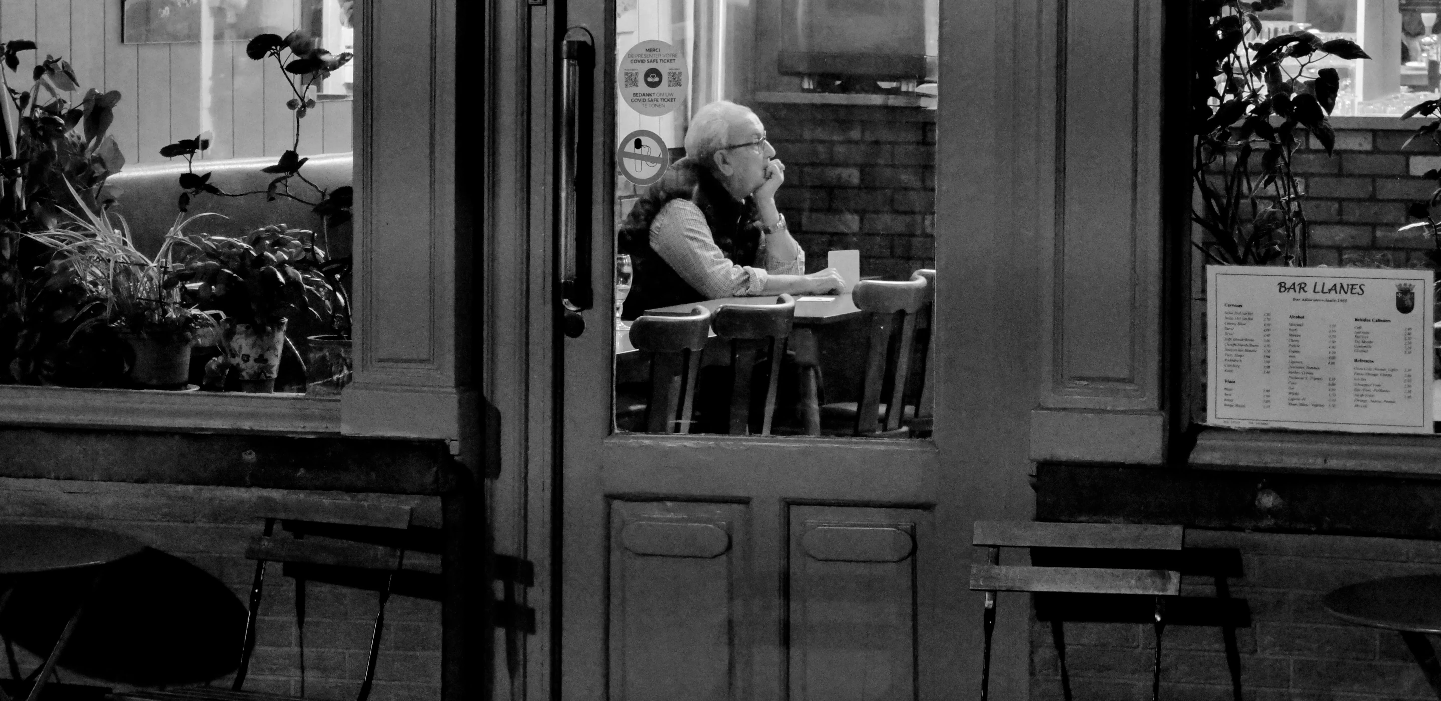 photo d'illustration en noir et blanc : un homme pensif dans un café