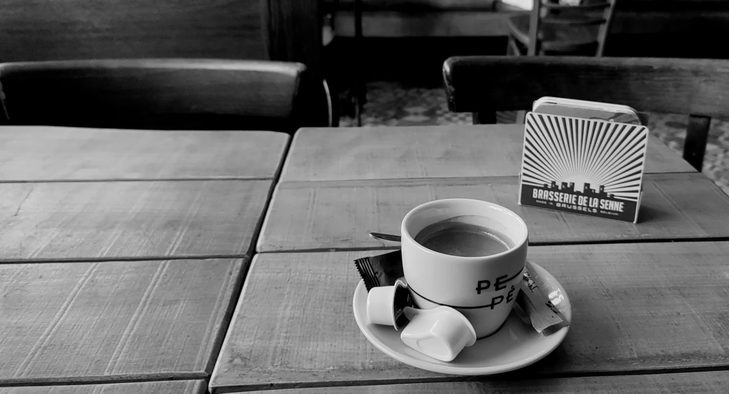 Photo noir et blanc d'une tasse de café sur une table en bois